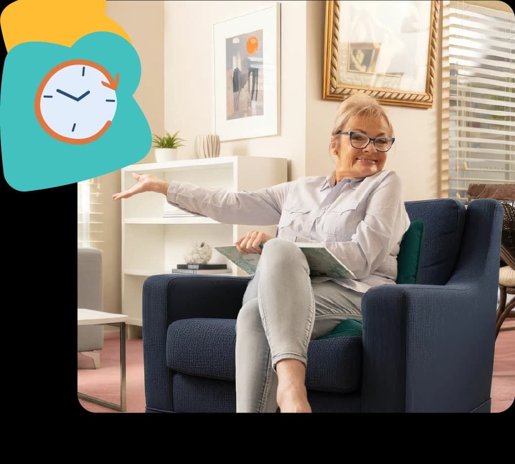 Paula Duncan sitting on a sofa smiling, enjoying a relaxed moment
