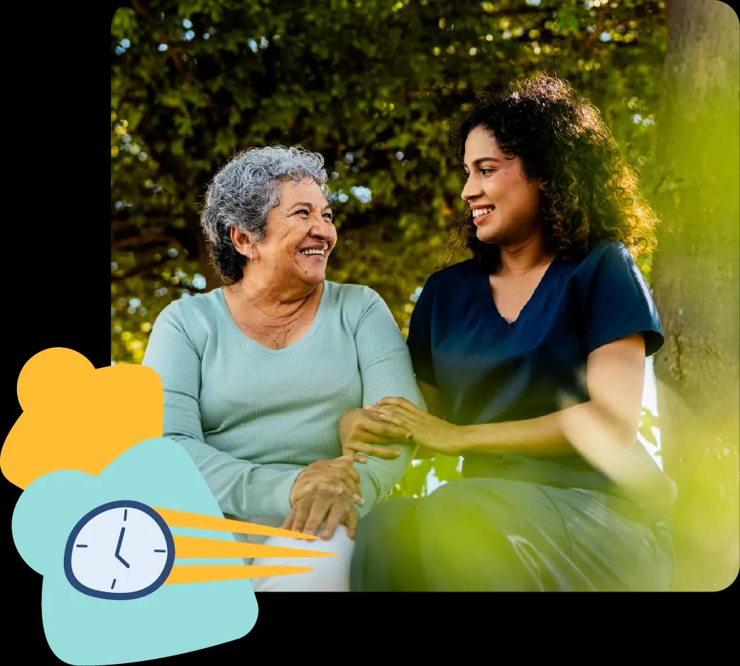 Mother and daughter sitting together in a park, smiling and sharing a moment of connection and care.