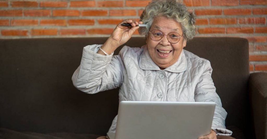 elderly woman making decision on computer