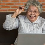 elderly woman making decision on computer